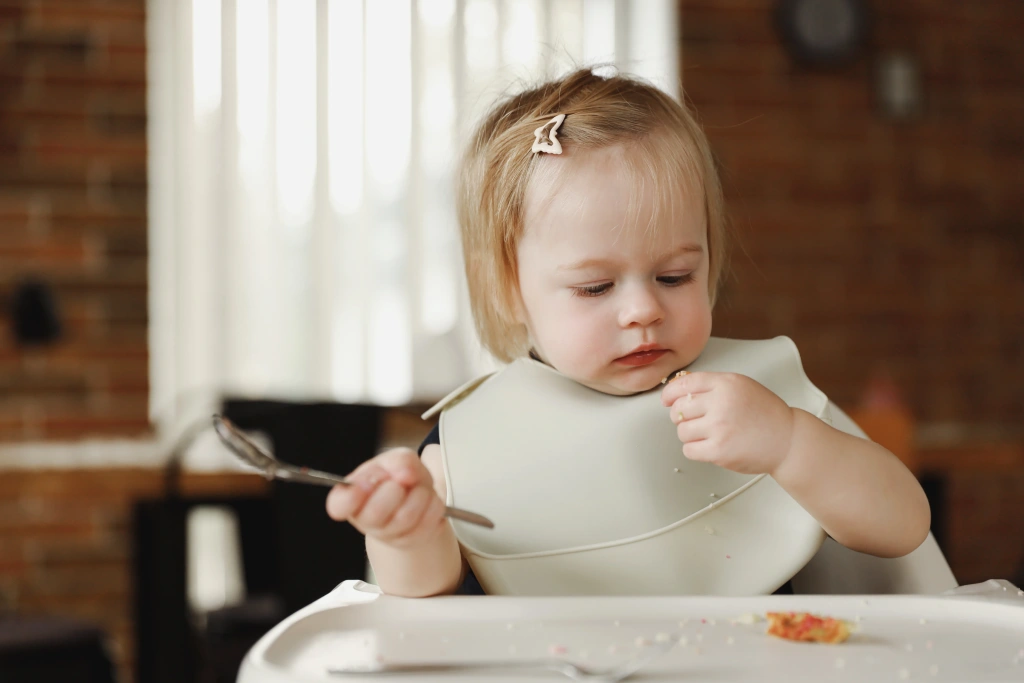 infant-girl-or-toddler-sitting-on-high-chair-eati-2025-09-10-03-24-39-utc.webp